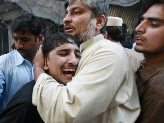 A man wept at the site of a bomb attack and ambush in the Peshawar, in Pakistan's North West Frontier Province.