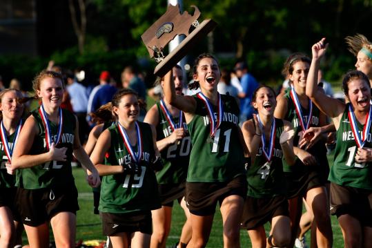 Westwood High girls celebrate after capturing the Division 1 state lacrosse crown in Worcester last week.