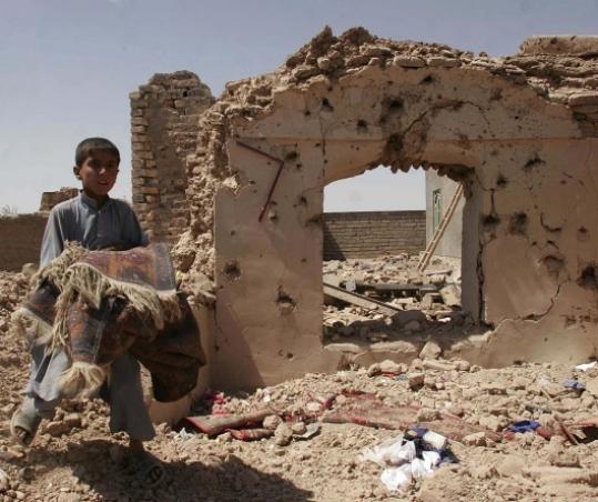 A boy whose house was destroyed by a US airstrike carried what was left of his belongings. Deadly airstrikes have prompted calls for better training to reduce civilian casualties.