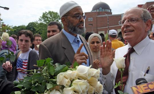 Imam Abdullah Faaruuq (left) and Charles Jacobs argued over the merits of the new mosque in Roxbury (in background) after supporters of the mosque presented Jacobs and other protesters with white roses in a gesture of peace.