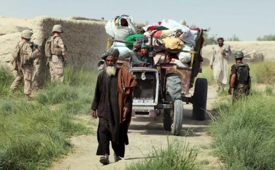 Afghan villagers streamed past US Marines in southern Helmand Province to return home yesterday.