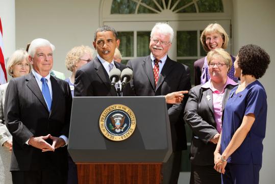 President Obama spoke in the Rose Garden alongside Senator Chris Dodd (left), nurses, and other members of Congress.