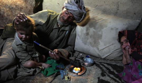 Islam Beg of Sarab village in the Badakshan province of Afghanistan offered his opium pipe to his grandson after having an early-morning smoke recently.