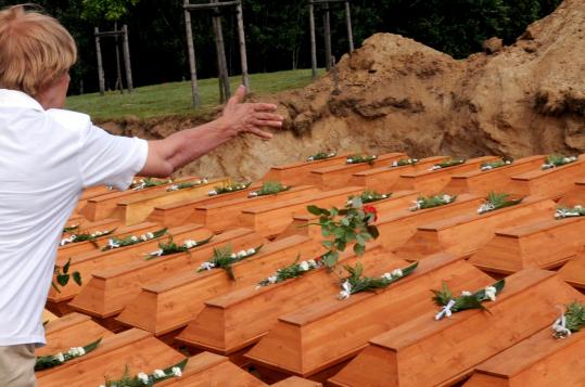 A mourner yesterday tossed a rose onto caskets containing the remains of World War II victims believed to be German civilians.