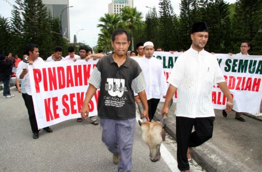 Dozens of Malaysian Muslims paraded yesterday with the head of a cow, a sacred animal in Hinduism.