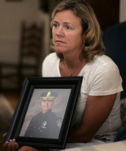 Kathy Webber holds a portrait of her late husband, Southborough Police Chief William Webber.