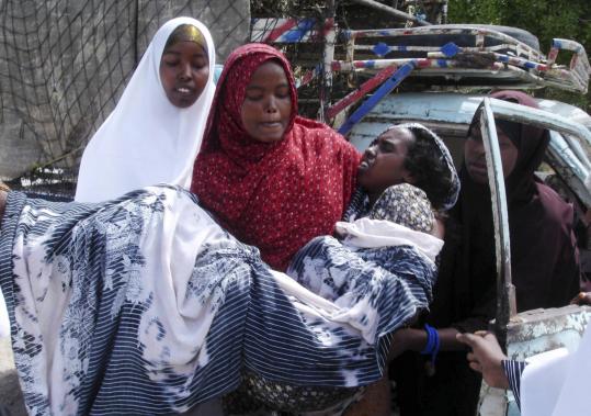 A woman injured during a suicide bomb attack at the base for the African Union’s peacekeepers in Mogadishu was carried by a relative on the way to a hospital yesterday. Leaders of the Islamist group Shabab claimed responsibility for the attack.