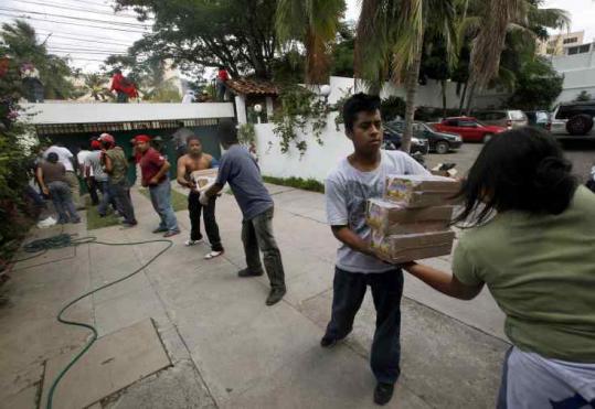 Supporters of Honduras’s ousted president, Manuel Zelaya, passed boxes of groceries at Brazil’s Embassy yesterday in Tegucigalpa. Troops still surrounded the embassy.