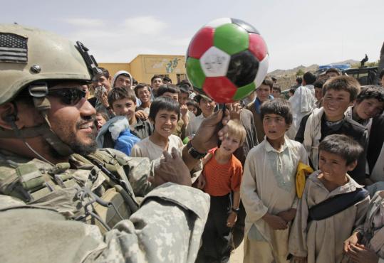 A Special Forces soldier entertained children at a school in Nili by spinning a soccer ball on a pen. The soldiers bring gifts to all the villages they visit, but have local officials distribute them.