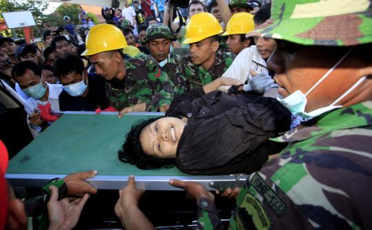 A rescue team carried out a survivor named Suci who had been trapped in a building in Padang, Indonesia, since Wednesday’s earthquake.