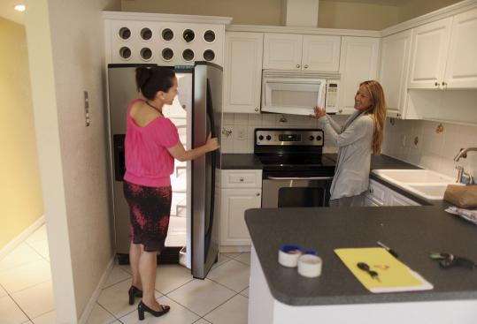 Realtor Shellie Young shows Gloria Arboleda a home for sale in Miami last week. Florida home values have been hit hard.