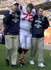 Patriots personnel help Matt Light, who suffered a right knee injury vs. Denver.