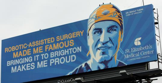 “In the hands of experienced surgeons like myself, we get at least equal and more likely superior results,’’ said Dr. Ingolf Tuerk, chief of urology at St. Elizabeth’s Medical Center in Brighton, who is featured on a Massachusetts Turnpike billboard (above) promoting robot surgery at the hospital.