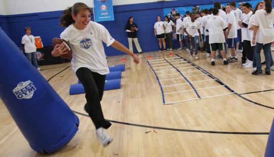 Pickering eighth-grader Christina Lannon runs the “running back drill’’ after a pep rally with the Patriots’ Stephen Gostkowski.