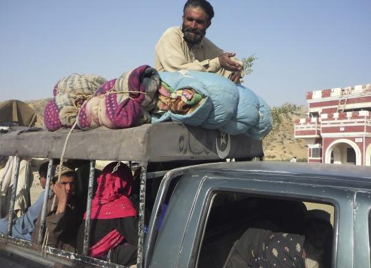 A Pakistani tribal family fleeing South Waziristan waited for security clearance upon their arrival at a checkpoint near Dera Ismail Khan yesterday.
