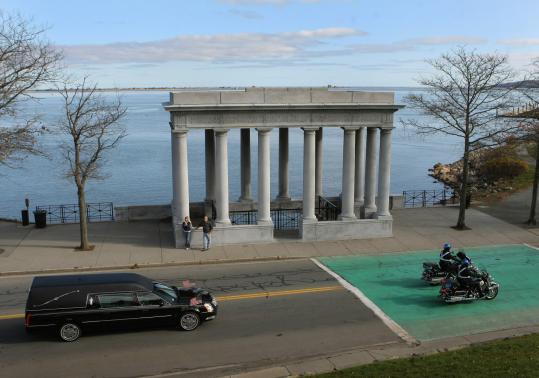 A hearse carrying Sergeant Benjamin Sherman’s body traveled past Plymouth Rock Memorial. A funeral will be held tomorrow.