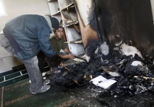 Palestinians inspected remnants of burnt copies of the Koran in a mosque in the West Bank village of Yasuf yesterday.