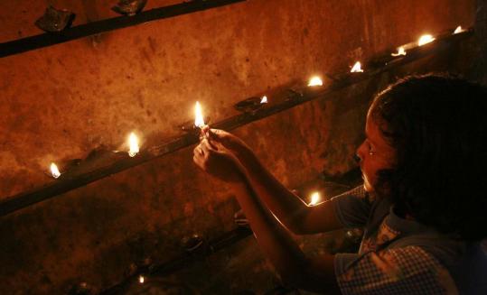 A girl lighted oil lamps at a Buddhist temple in Peraliya, Sri Lanka, yesterday in memory of those killed in the 2004 tsunami.