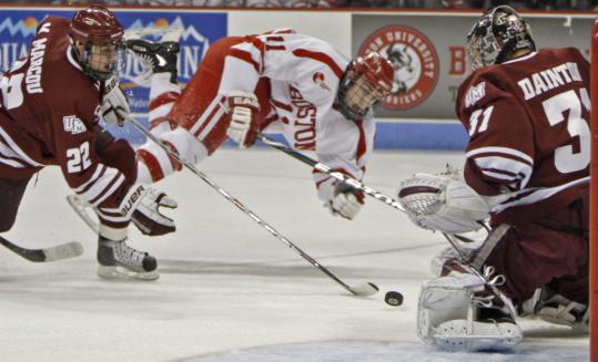 BU senior forward Zach Cohen, who scored twice in the Terriers’ win, gets some air time after sending a shot on UMass goalie Paul Dainton in the first period.