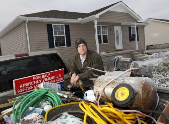 Isaac Zimmerle stood near his truck Saturday in front of a home on which he was forced to halt construction in Chapel Hill, Tenn., after unsuccessful attempts to find a buyer.