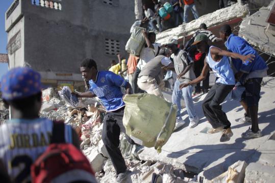 People looted yesterday from a destroyed store in Port-au-Prince, and young men were seen downtown with machetes.