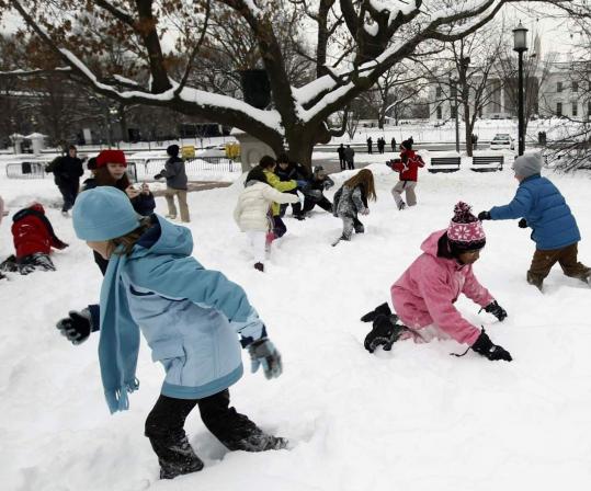 Children visiting yesterday from Hancock Day School in Savannah, Ga., played in the snow in a park in front of the White House.