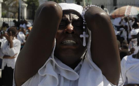 A woman prayed at a service outside the ruins of a cathedral held in commemoration of the Jan. 12 earthquake in Haiti.