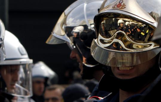 A protesting firefighter   in Athens shouted slogans condemning Greece’s austerity measures as  riot  police cordoned off the parliament building during a demonstration   Tuesday.