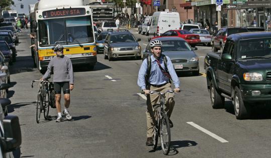 Bicyclists share the road with motorists and public transit on Massachusetts Avenue in Boston.
