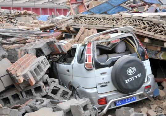 Rubble from a  building destroyed in Wednesday’s earthquake crushed a vehicle in Yushu  County in the Qinghai Province in northwest China. Relief efforts have  been slowed by heavy traffic on the single main road from the Qinghai  provincial capital.