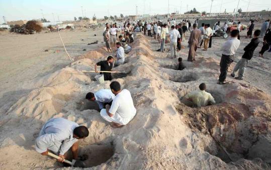 Gravediggers worked as the bodies of victims of a wave  of bombings arrived for burial in the Shi’ite holy city of Najaf  yesterday.
