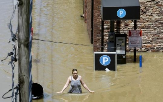 A woman waded through flood water on a downtown sidewalk in Nashville, which saw more than 13 inches of rain.
