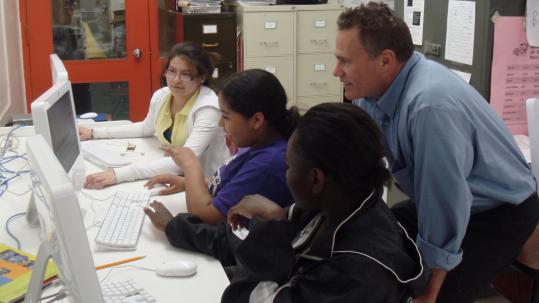 In the computer lab of Edward Devotion School in Brookline, students (from left) Sabrina Vallejo, Thalia Morales, and Sherly Estime work with instructor J.T. Lenoch.