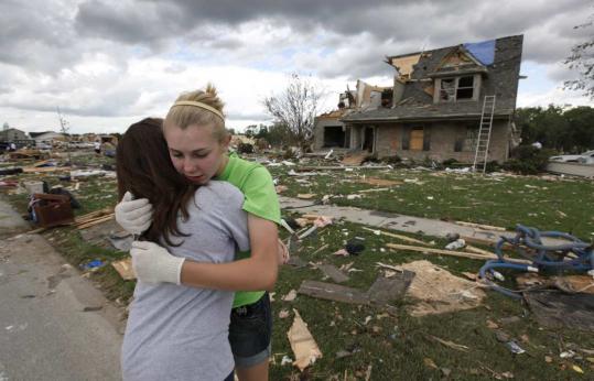 Neighbors Mary Hoefflin (left) and  Lauren Densic consoled each other amid the destruction on Main Street in  Millbury, Ohio, yesterday, the day after a tornado hit.