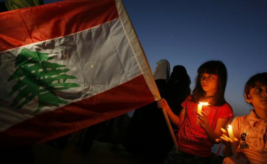 A  girl held a candle in Gaza City as she waved the Lebanese flag during a  rally to support those seeking to bring aid by boat.