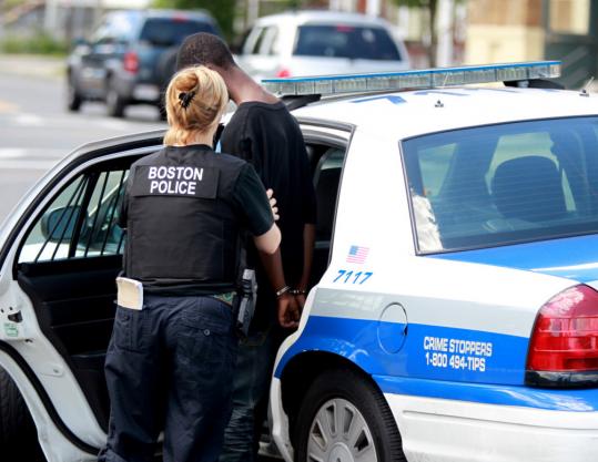 An officer placed a young man in a car after an arrest on Norfolk Street yesterday. Boston police attempted to get known offenders off city streets prior to the holiday weekend.