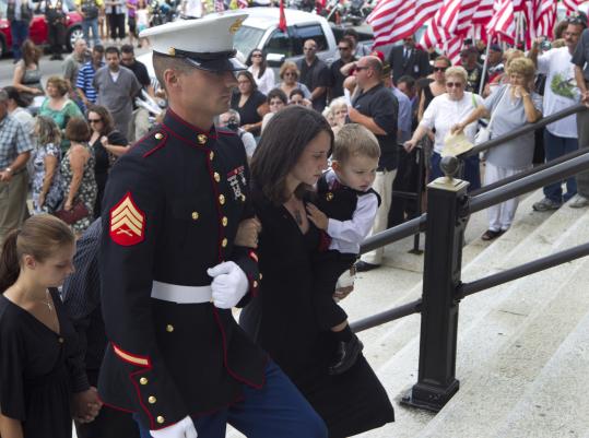 Cynthia Marie Fagundes held her  son, Cazzian, as a Marine escorted her into a Fall River church for her  husband’s funeral. Corporal Paul Fagundes died July 4 in Guantanamo Bay.  She is pregnant with the couple’s second child.