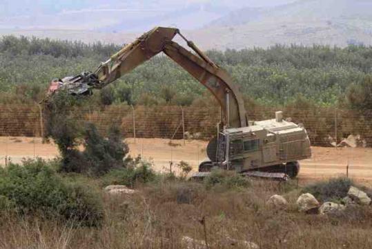 Israeli soldiers cut trees in disputed land along the Israel-Lebanon border yesterday, one day after a similar operation led to gunfire and shelling that left two Lebanese soldiers, an Israeli commander, and a Lebanese journalist dead.