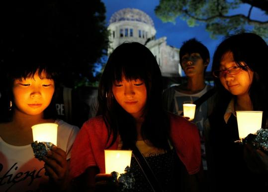 Japanese youths held candles while praying for victims of the 1945 atomic bombing at the Atomic Bomb Come at Peace Memorial Park yesterday in Hiroshima, Japan. The city will mark the 65th anniversary of the world’s first atomic attack today.