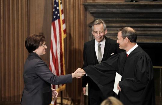 Chief Justice John G. Roberts congratulated Elena Kagan after she was sworn in as the Supreme Court’s newest justice. Jeffrey Minear, counselor to the chief justice, held the Bible at the Supreme Court building in Washington.