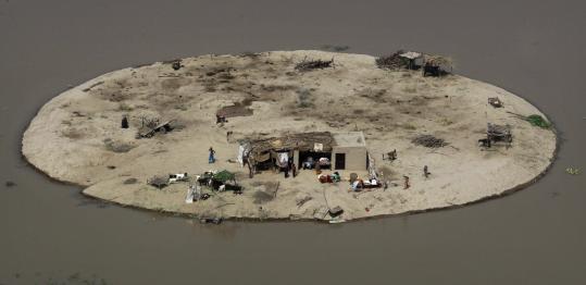 A Pakistani family stood on their farm compound surrounded by flood waters, seen by a Pakistan Navy helicopter distributing emergency aid near Bachel in Sindh Province.