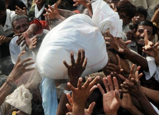 Survivors struggled for relief bags in Kot Addu, Pakistan, yesterday. Flooding has affected 17 million Pakistanis, and engulfed a fifth of the country.