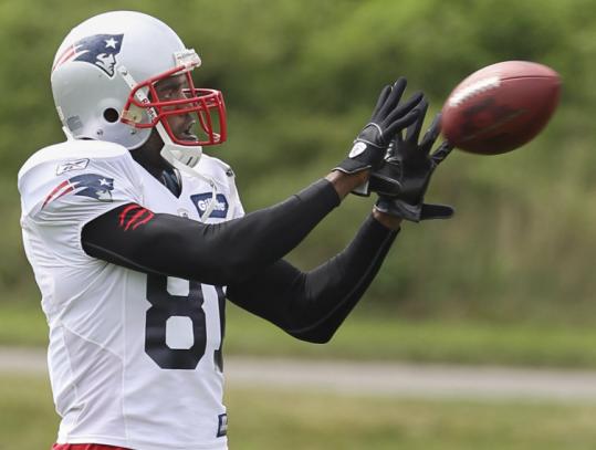 In his return to practice after illness kept him out Wednesday, Patriots receiver Randy Moss hauls in a pass yesterday.