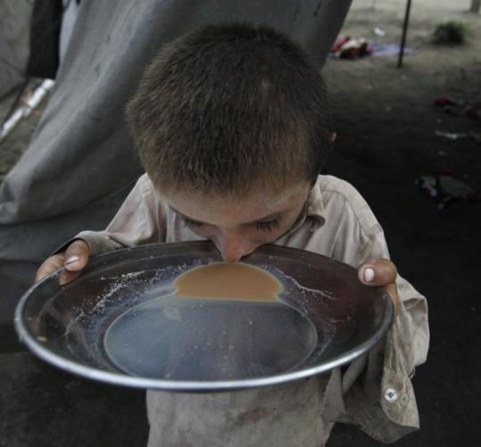A flood victim drank tea from a pan at a relief camp at Sukkur in Pakistan’s Sindh Province yesterday.