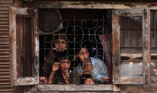 A Kashmiri family looked out their window after a clash between soldiers and protesters during curfew yesterday.
