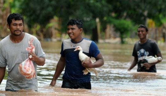 Residents waded through a flooded area in central Honduras following the passage of Tropical Storm Matthew yesterday.