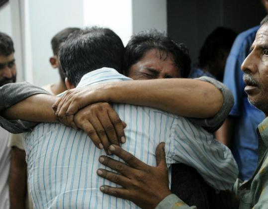 Men yesterday mourned the death of a relative following attacks in a market in Karachi, Pakistan. At least 48 people have been killed since Saturday in the city.