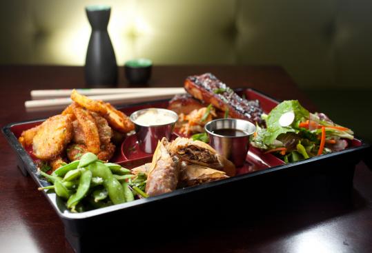 Bento B features fried pickles, a salad, spring rolls of duck confit and shiitake mushrooms, and ribs.