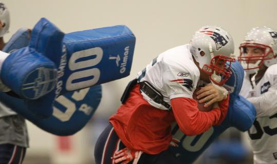Aaron Hernandez (left) and Wes Welker tangled with each other and some pads at practice.