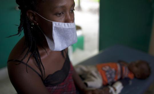 A woman waited yesterday at a hospital in Archaie, Haiti, with her son, who suffers from cholera symptoms.